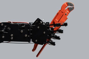 Tesisatçı anahtarıyla gerçek bir robot eli. Yapay zeka geliştirme kavramları veya yapay zeka tarafından iş değişikliği.