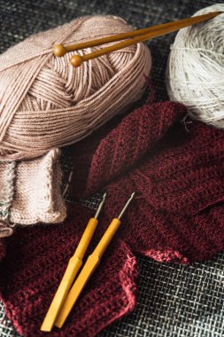 Yünlü iplikler, örgü iğneleri ve tığ işi kancalar.
