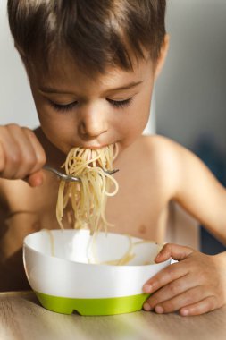 Sevimli çocuk en sevdiği yemeği yiyor, spagetti..