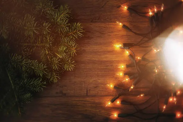 Dřevěný Povrch Zdobený Třpytivými Vánočními Světly Svěžími Větvemi — Stock fotografie