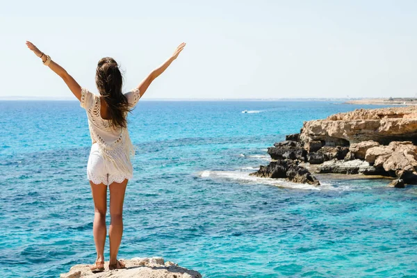 年轻女子站在悬崖边上 从著名的希腊角的观点看令人惊叹的景色 — 图库照片