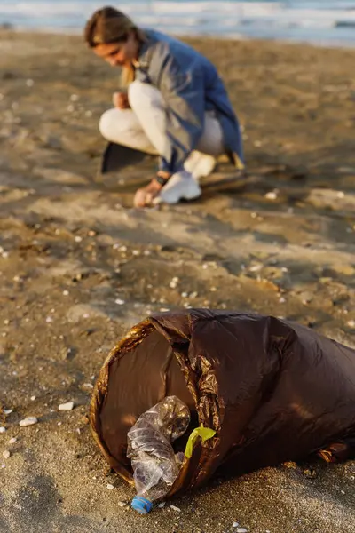 女性ボランティアは 自然をきれいに保つ努力に貢献するためにビーチでプラスチック廃棄物を集めています — ストック写真