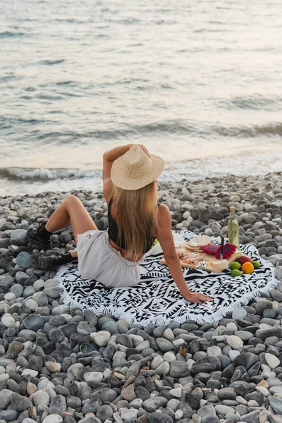 Stylowa Beztroska Kobieta Słomkowym Kapeluszu Urządza Spokojny Piknik Żwirowej Plaży — Zdjęcie stockowe
