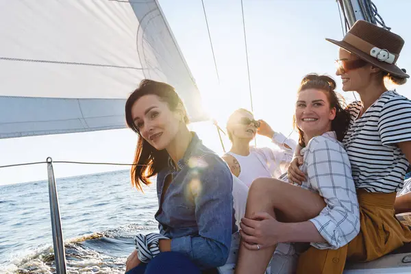 在海上航行的时候 在帆船上放松度假的快乐的女孩们 图库图片