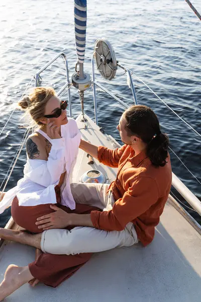 年轻貌美的夫妻在海上航行时在帆船上放松一下 免版税图库图片