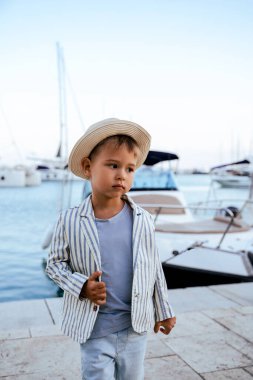 Marinada yatın yanında poz veren yakışıklı bir çocuğun portresi.