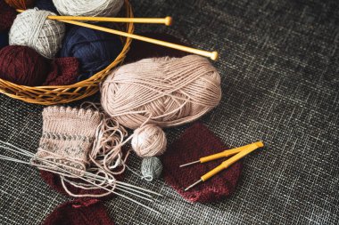 Çeşitli yün iplik ve örgü aletleriyle dolu sepet..