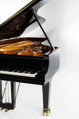 Gri arka planda açık kapaklı lüks kuyruklu piyano