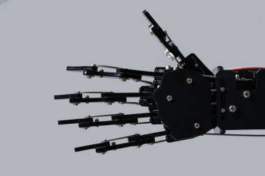 Gerçek robotun eli gri arka planda izole edilmiş. Yapay zeka geliştirme ve robot işlem otomasyonu kavramları.