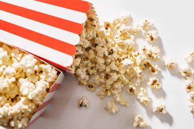 Beyaz arka planda lezzetli patlamış mısırlı klasik çizgili kovalar..