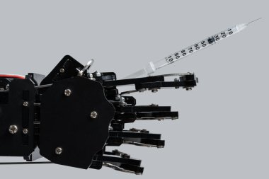 Şırıngayla gerçek bir robot eli. Yapay zeka kavramı ve tıp alanında robotlar.