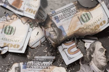 Yanmış yüz dolarlık banknotların kalıntıları ekonomik kriz, enflasyon ve iş başarısızlığını simgeliyor..