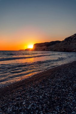 Kıbrıs 'taki Kourion plajında gün batımlı güzel deniz manzarası.