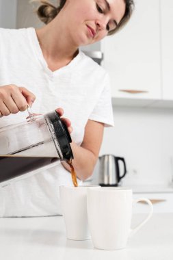 Fransız basınına yakın çekim ve beyaz kupaya dökülen koyu kahve..