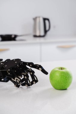 Yeşil elmayla gerçek robotun eline yaklaş. Yapay zeka geliştirme ve robot işlem otomasyonu kavramı.