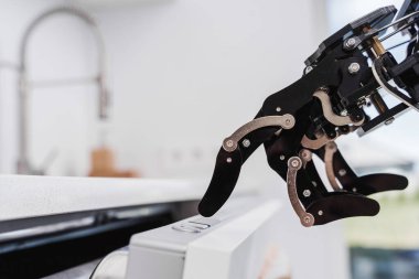 Bulaşık makinesinde gerçek bir robot el düğmesi. Yapay zeka geliştirme ve robot işlem otomasyonu kavramı.