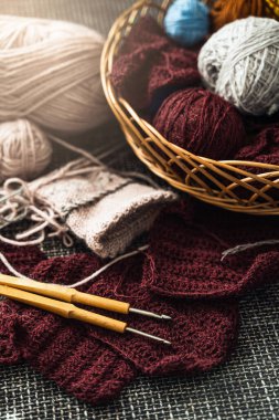 Çeşitli yün iplik ve örgü aletleriyle dolu sepet..