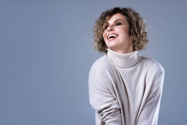  Balıkçı yaka kazak giyen şık bir genç kadının stüdyo portresi..