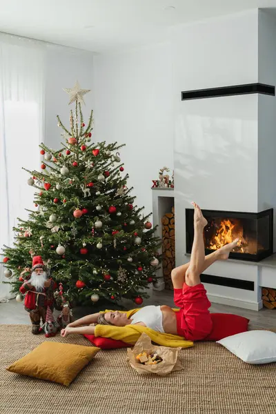 Young Woman Lies Glowing Fireplace Cozy Living Room Adorned Christmas — Stock Photo, Image