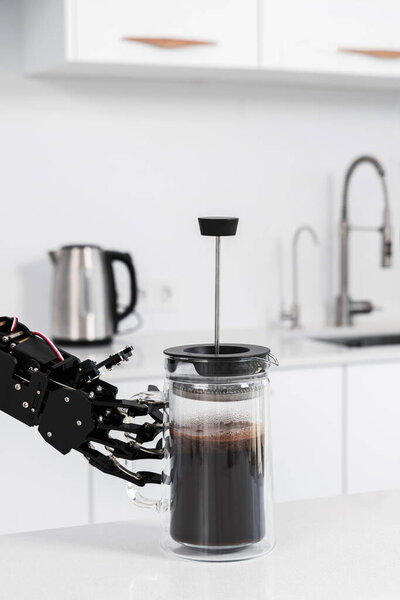 Real robot's hand and French press with black coffee. Concept of  robotic process automation.