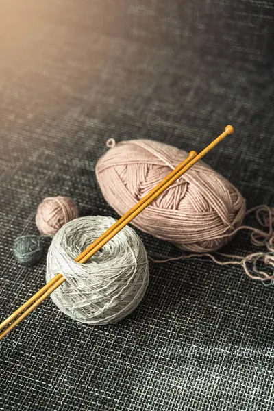 Closeup of woolen threads and wooden knitting needles.