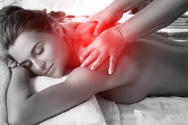 Young woman during healing back massage therapy in Asian traditional clinic