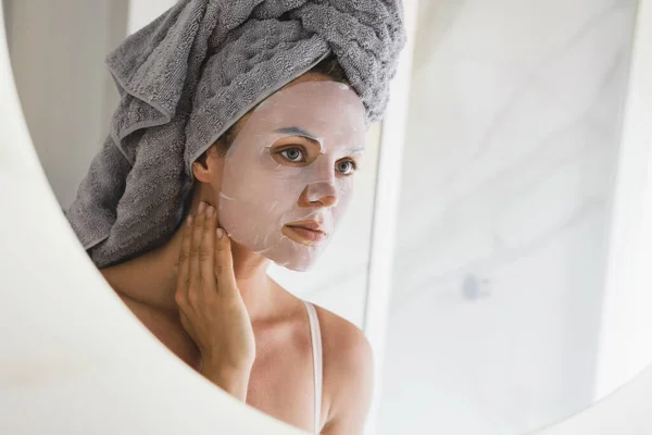 Hermosa Mujer Baño Con Máscara Hoja Aplicada Cara Mirando Espejo — Foto de Stock