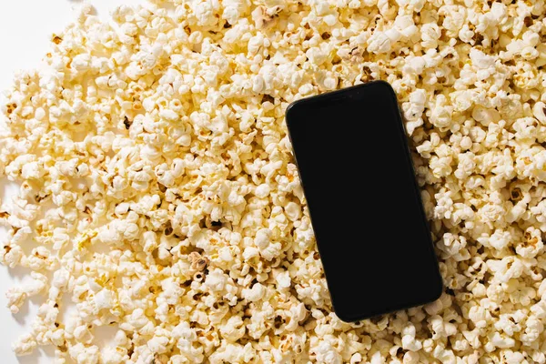 Lezzetli patlamış mısır ve tasarımın için boş ekranlı akıllı telefon..