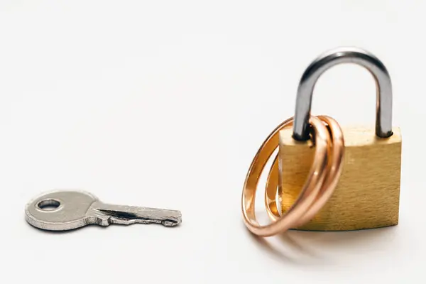 Маленький Ключ Два Золотых Обручальных Кольца Замке Белом Фоне — стоковое фото