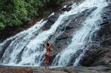 Mayo giymiş Güzel Genç Kadın Ton Phrai, Şelale yakınlarında poz veriyor..