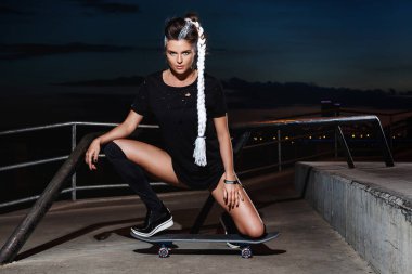 Kaykay parkında kaykaylı güzel bir kadın.