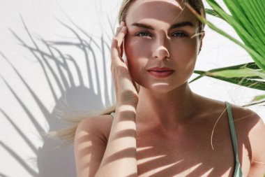 Palmiye Gölgesi Beyaz Duvarda Yaprakları Olan Genç Kadın.