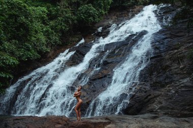 Şelale yakınlarında poz veren Güzel Çıplak Kadın.