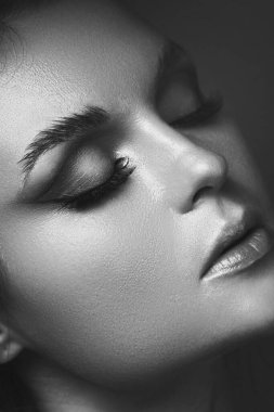 Göz makyajlı ve kusursuz ciltli bir kadın portresi..