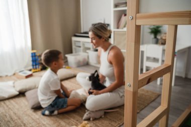 Mother and Little Son Playing Together with Stuffed Toys on the Floor at Home. clipart