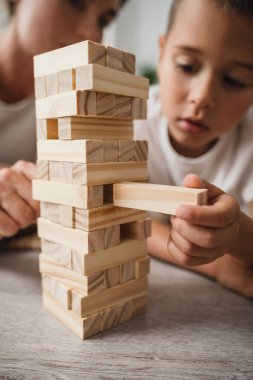 Anne ve küçük oğlu yerde tahta bloklarla oynuyorlar..