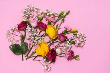 Neşeli bir görüntü için pembe bir zemine yayılmış canlı çiçekler..