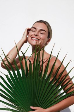 Beyaz arka planda Palm Leaf 'li Güzel Genç Kadın Portresi.
