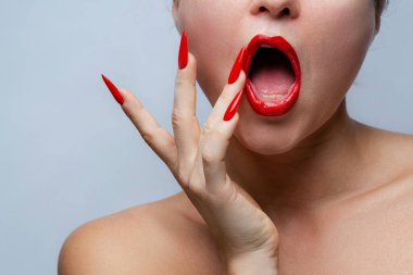 Kırmızı Stiletto Çivileri ve Uyumlu Ruj ile Kadının Yüzüne Yakın Çekim.