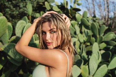 Dikenli armut kaktüsünün canlı yeşilliğine karşı kadın portresi.