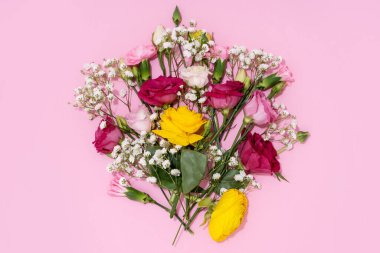 Neşeli bir görüntü için pembe bir zemine yayılmış canlı çiçekler..