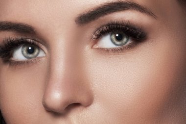 Kirpik uzatma ve kaş düzeltmesinden sonra bir kadının gözlerinin yakın çekimi..