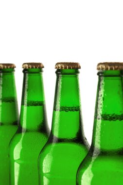  Beyaz arka planda yeşil bira şişeleri.