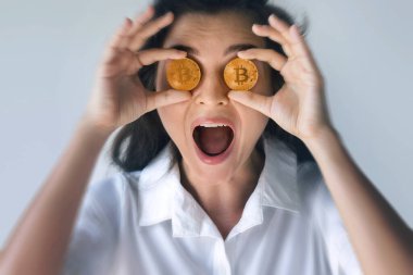 Gözünün üstünde Bitcoin Paraları olan Şaşkın Kadın Kripto Para Odağını Sembolize Ediyor.