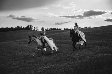 Güneş Işığı Tarlası 'nda Atlara Binen Şık Giyimli İki Kadın.