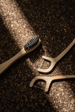 Bambu diş fırçası ve diş ipi tıpa yüzeyinde..