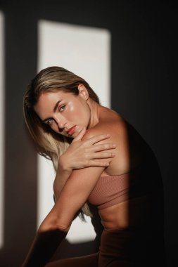 Güneş ışığında uzun sarı saçlı genç bir kadının portresi..