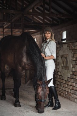 Binicilik Giyinen Kadın Ahırda Atla Duruyor.