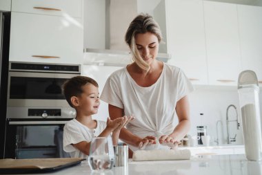 Mutlu anne ve oğlu modern bir mutfakta birlikte yemek pişiriyorlar.. 