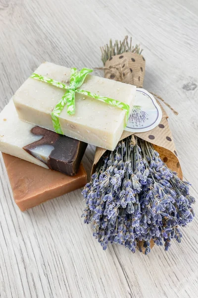 Natural handmade soap and dried lavender flowers in light wooden background. Bio organic cosmetics. Plant base.